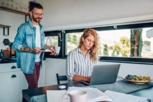 Paar im Home-Office - er besorgt ihr einen Tee- Achtsamkeit führt zur Ausgeglichenheit und Work-Life-Balance