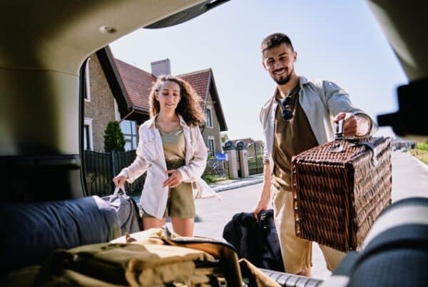 Paar lädt gemeinsam das Auto, um entspannt in den Urlaub zu starten