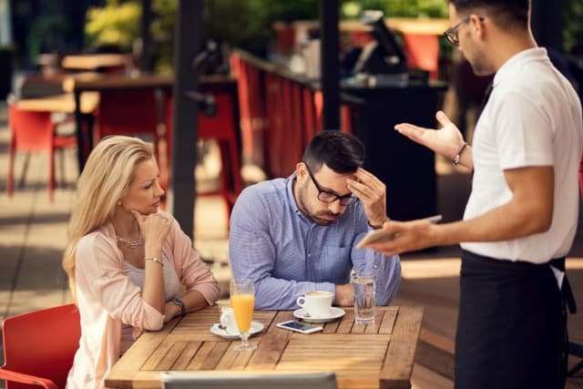 unentspanntes Paar in einem Cafe am ersten Urlaubstag